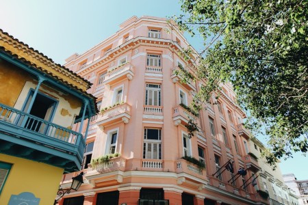 Una foto de una calle en la ciudad con ventanas, balcones y edificios. Las ventanas son de diferentes tamaños y formas, y los balcones están llenos de plantas y flores. Los edificios son de diferentes colores y alturas, y están hechos de diferentes materiales. La calle está llena de vida y movimiento, y la imagen es una hermosa representación de la vida urbana. Una foto de una calle en la ciudad con ventanas, balcones y edificios.