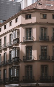 Esta foto muestra una calle urbana con edificios de apartamentos. Los edificios son de diferentes alturas y colores, y están llenos de ventanas. La calle está llena de gente, y se puede ver que hay mucho movimiento. La foto es un recordatorio de la diversidad y la energía de la ciudad. Una vista de una calle urbana con edificios de apartamentos.