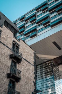 Esta foto muestra un grupo de edificios de apartamentos con ventanas y balcones. Los edificios son de diferentes alturas y colores, y están ubicados en una ciudad. La foto es un recordatorio de la diversidad y la belleza de la arquitectura urbana. Una foto de un grupo de edificios de apartamentos con ventanas y balcones.