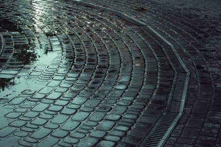Vista de un sistema de drenaje circular en el pavimento de adoquines, evidenciando su capacidad para eliminar el agua acumulada después de una lluvia. Sistema de drenaje circular en pavimento de adoquines.