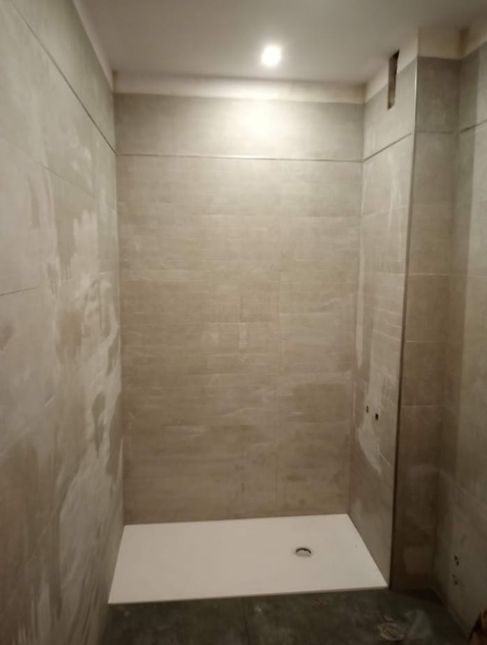 Renovación del cuarto de baño gris 5 Cuarto de baño en remodelación con preparación de superficie para azulejos.