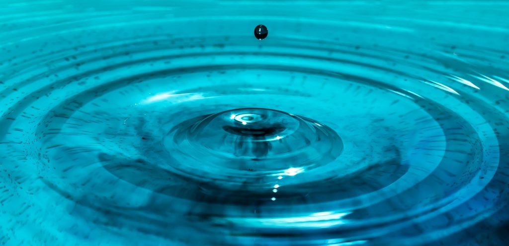 Reparación y restauración de cazoleta de desagüe deteriorada 2 Caída de gotas de agua en un fondo azul
