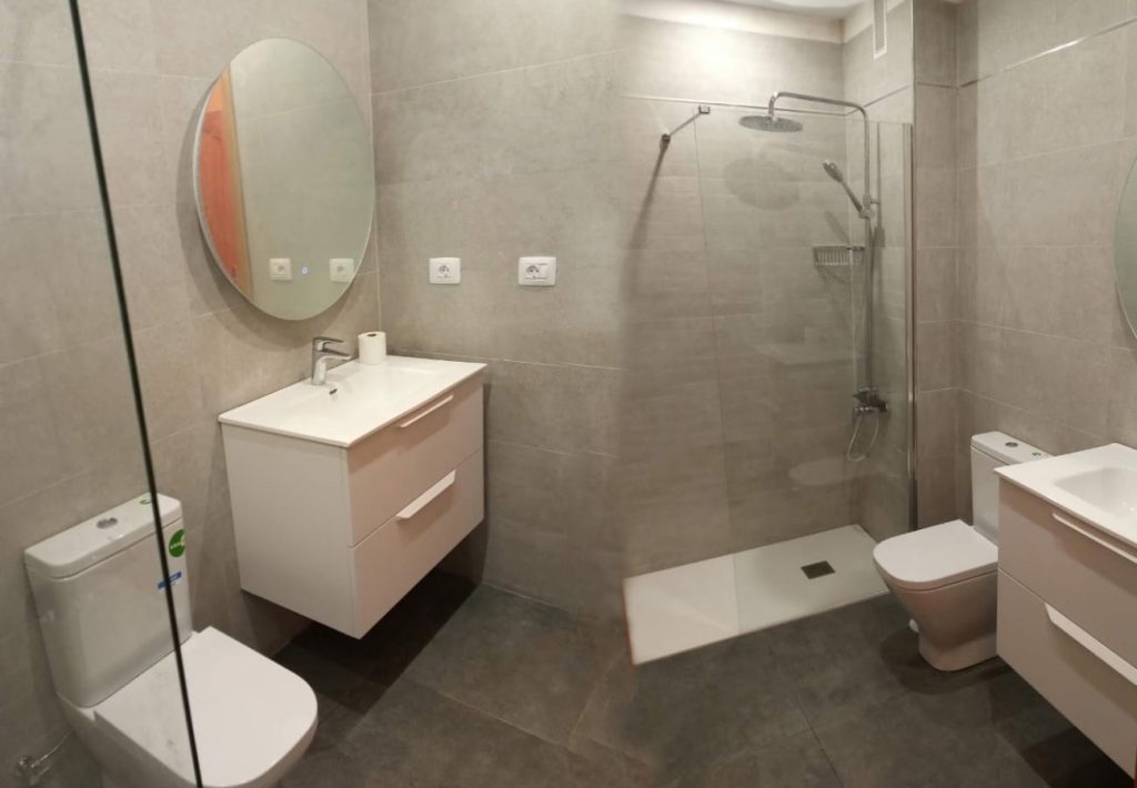 Renovación del cuarto de baño gris 2 Cuarto de baño renovado con estilo moderno y elegante.