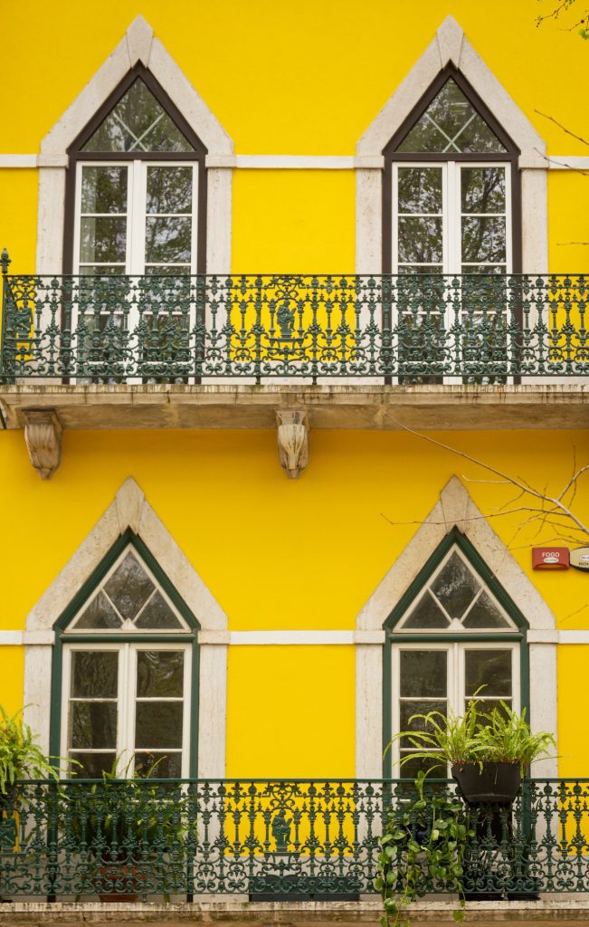 Rehabilitación de fachadas y edificios 2 Una foto de una calle en una ciudad con casas amarillas.
