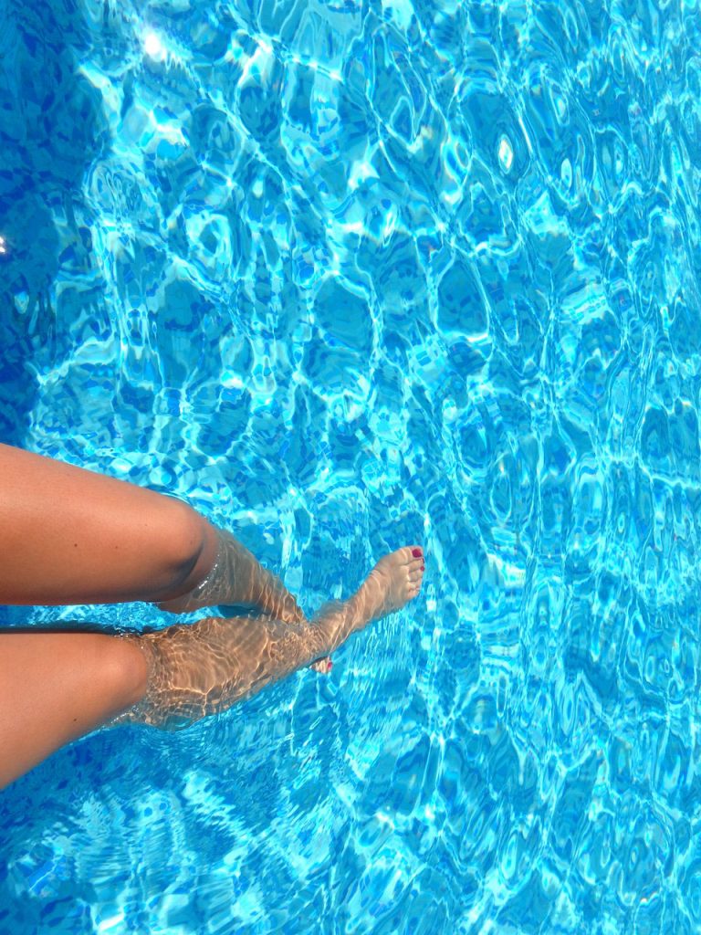 Renovación de una piscina 6  Imagen de unas piernas sumergidas en una piscina recién reformada, disfrutando de un refrescante baño.