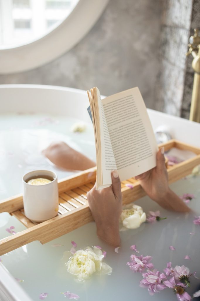 Renovación de cocinas y baños: claves para una reforma exitosa 3 Bañera relajante con flores flotantes y una mujer disfrutando de un momento tranquilo