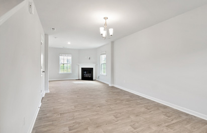 Servicios 11 Imagen de un amplio salón rectangular recién reformado, con un suelo de tarima de madera en tono marrón claro y techos lisos de color blanco, creando un ambiente luminoso y acogedor.