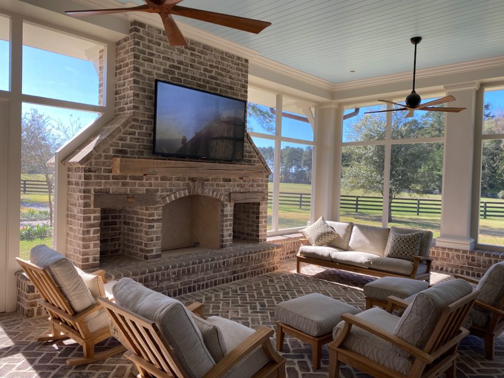 Diseño y construcción de chimeneas de leña para un ambiente cálido y acogedor 2 Salón acogedor con chimenea de ladrillo rustico y vistas al campo.