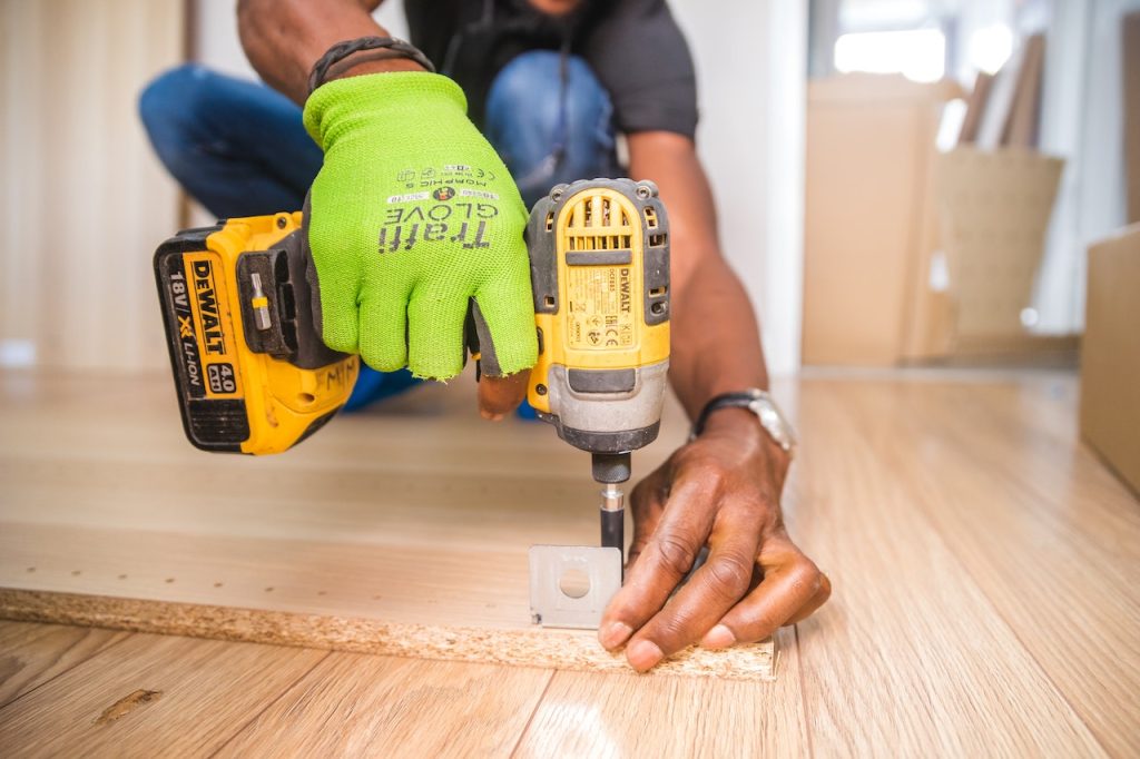 Carpintería de madera, aluminio y PVC 3 Trabajador ensamblando un mueble de madera con una máquina de atornillar