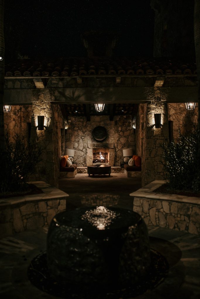 Jardín de una casa de campo con una encantadora chimenea en el porche.