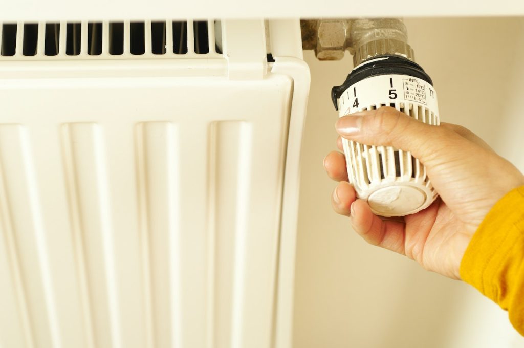 Mantenimiento en instalación de sistemas de climatización y calefacción 4 Una mano ajustando una válvula de control de temperatura.