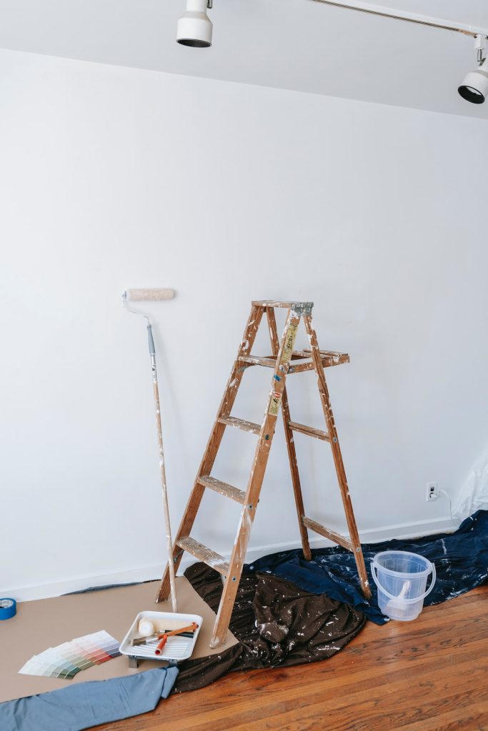 Pintura y decoración 2 Pared recién pintada en blanco con utensilios de pintura y protección de suelo