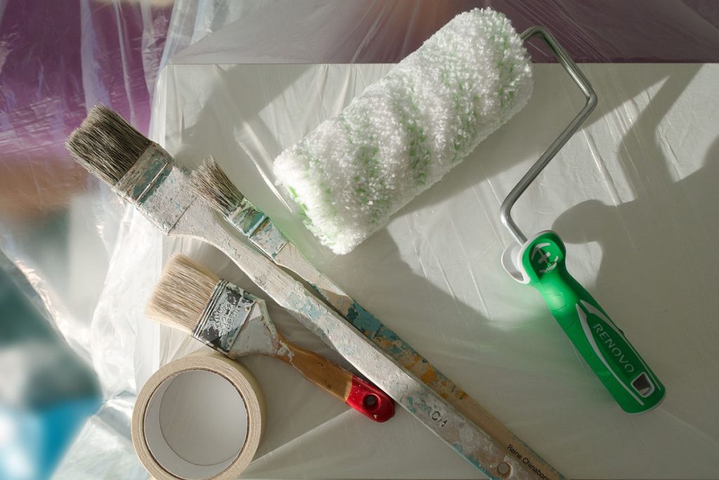 Pintura y decoración de interiores 5 Herramientas de pintura sobre una superficie protegida con plástico.